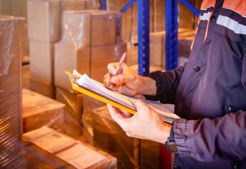 In a warehouse, a man with a clipboard reviews self-storage unit contracts for Mountain View, CA.