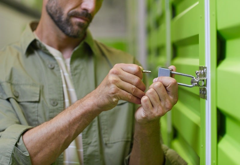 A man opens a green storage unit, shows self-storage options of various sizes in Mountain View, CA.