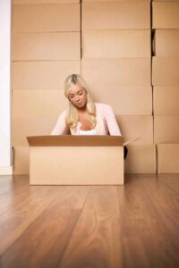 A young woman packing boxes indoors symbolizes moving with self-storage in Mountain View, CA