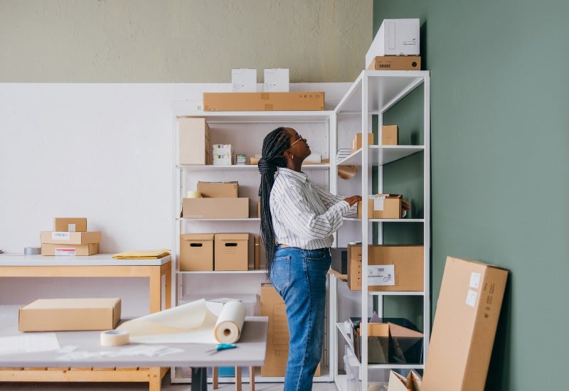 A woman organizing storage boxes for efficient business inventory management in Mountain View, CA