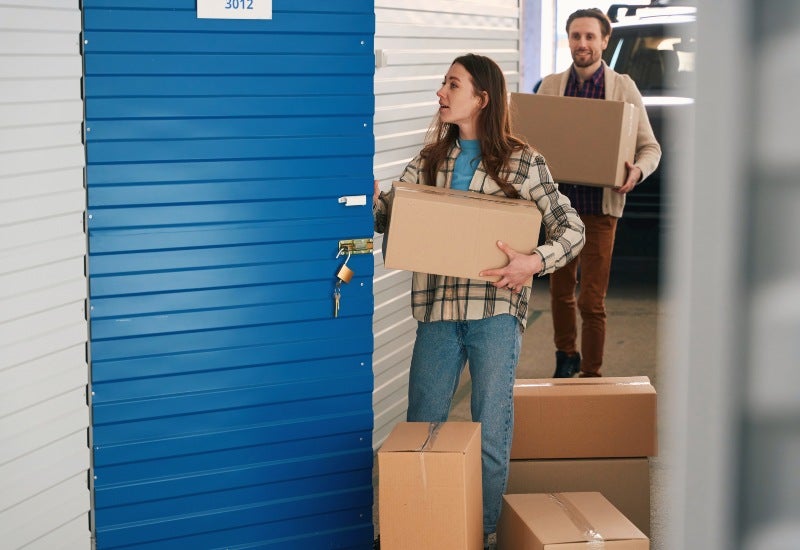 A couple moving boxes into a storage unit for long-term self-storage in Mountain View, CA