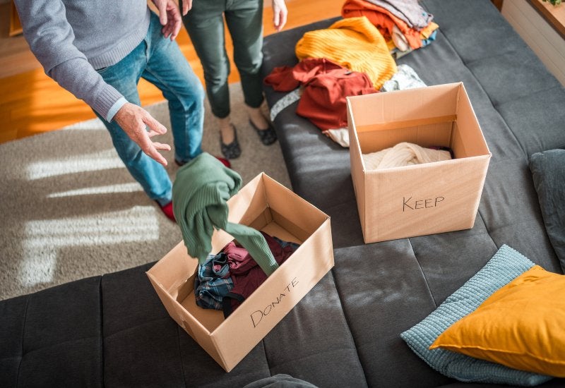 Two people decluttering clothes into boxes for summer storage units in Mountain View, CA